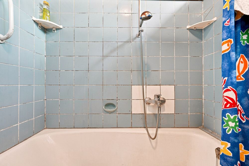 Badezimmer des Bungalows in Henstedt-Ulzburg mit Badewanne und Brausearmatur.