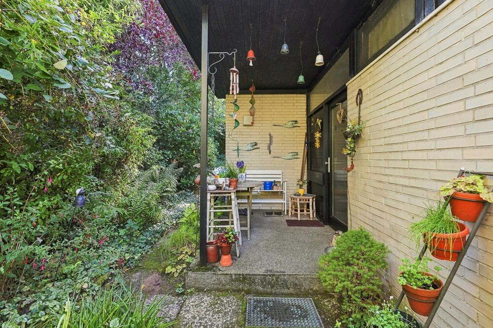 Überdachter Nebeneingang des Bungalows in Henstedt-Ulzburg mit Sitzplatz.