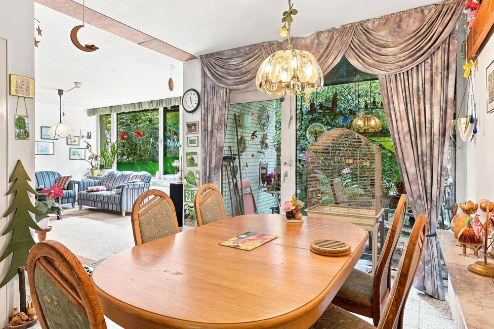 Essdiele des Bungalows in Henstedt-Ulzburg mit Esstisch und Zugang zur Terrasse.
