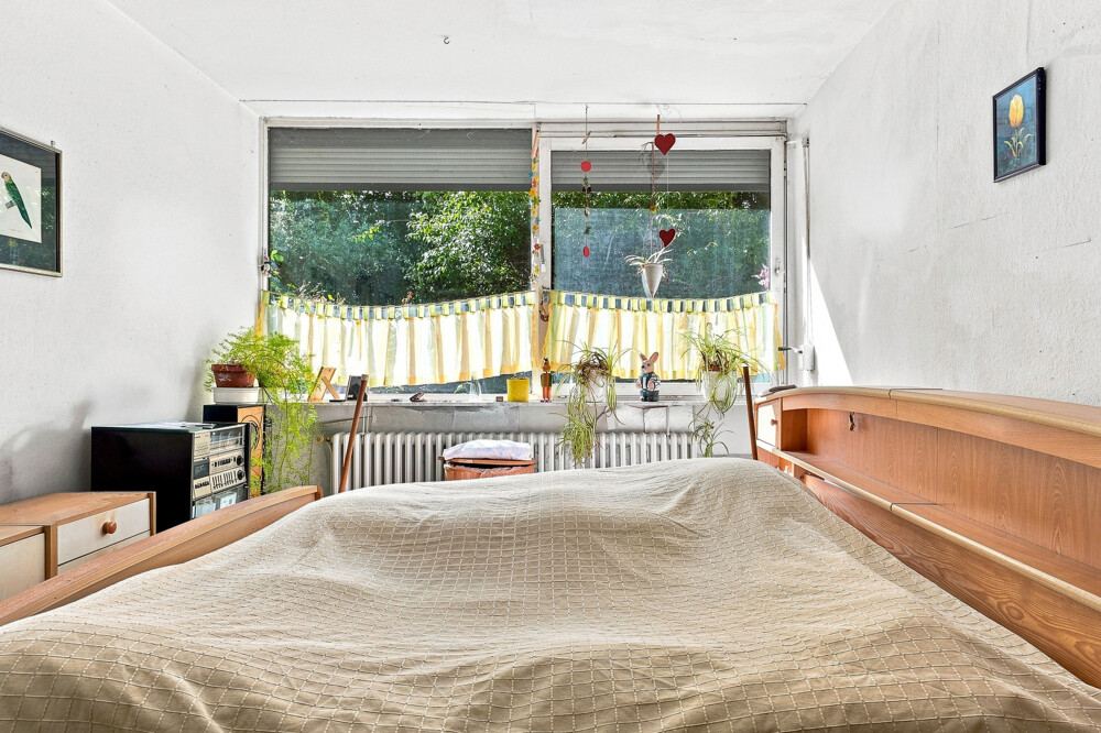 Schlafzimmer des Bungalows in Henstedt-Ulzburg mit Fenster zum Garten.