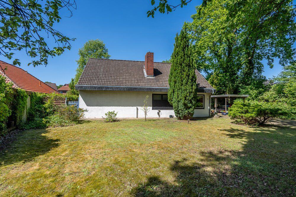 Rückansicht des Einfamilienhauses Kaltenkirchen mit Garten und Carport.
